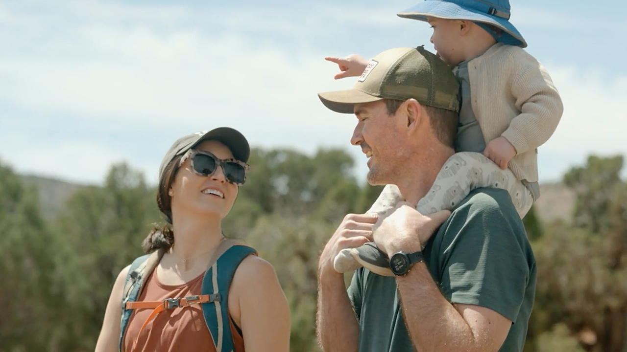Couple on a hike with toddler son on the dads shoulders